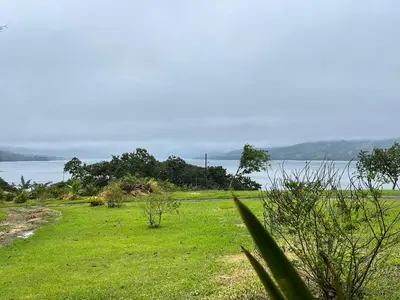 a field of grass with the ocean in the background at Little Paradise in Nuevo Arenal