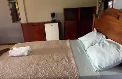 a bedroom with a large bed with a wooden headboard at Little Paradise in Nuevo Arenal