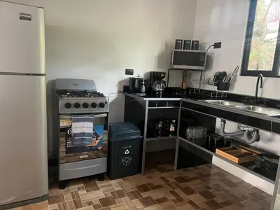 a small kitchen with a stove and a refrigerator at Live bambu in Caimital