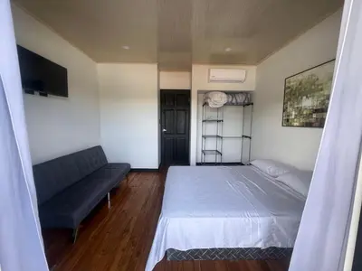 a bedroom with a bed and a couch at Live bambu in Caimital