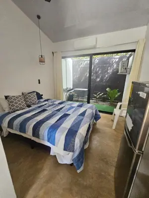 a bedroom with a bed and a large window at Uvita Boutique Studios in Uvita