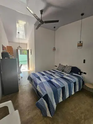 a bedroom with a bed with a blue and white comforter at Uvita Boutique Studios in Uvita