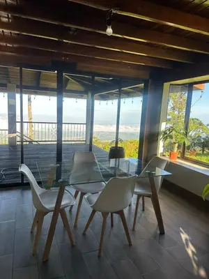 a dining room with a glass table and chairs at San Vicente Mountain in Colón