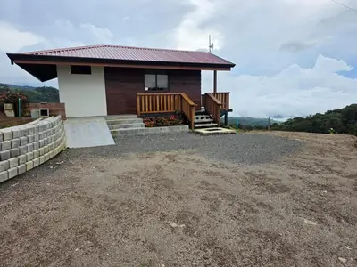 a small house with a porch and stairs to it at San Vicente Mountain in Colón