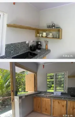 a kitchen with white walls and wooden cabinets at Casita colibri in Savegre