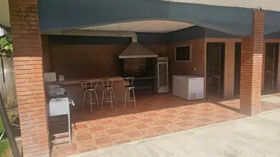 an outdoor kitchen with bar stools in a brick building at Casa Lapa Herradura Completa in Herradura