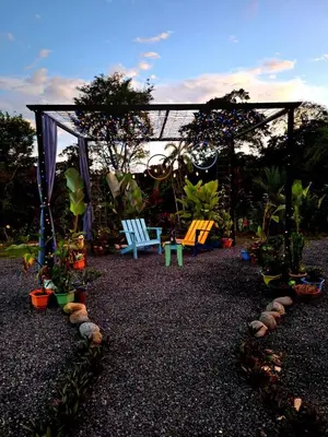 a garden with a gazebo and chairs and plants at Selvático Costa Rica in Chachagua