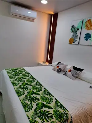 a bedroom with a bed with a green and white blanket at Selvático Costa Rica in Chachagua