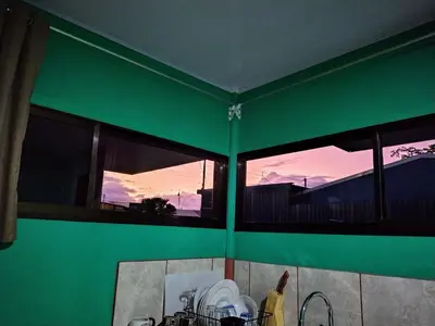 a green wall with windows in a kitchen with dishes at La Fortuna Brisas del Recuerdo in Fortuna