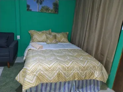 a bed in a bedroom with a green wall at La Fortuna Brisas del Recuerdo in Fortuna