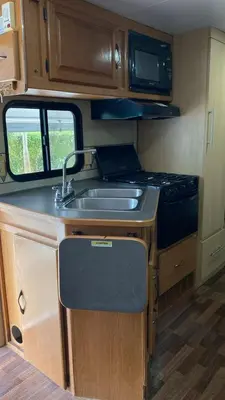 a kitchen with a sink and a stove in an rv at Tiny Soul in Santa Teresa Beach