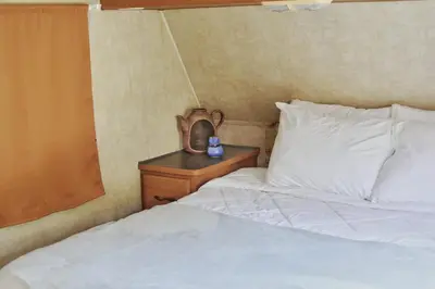 a bedroom with a bed and a nightstand with a clock at Tiny Soul in Santa Teresa Beach