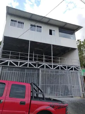 a red truck parked in front of a building at Hostel La Bambú in Quepos