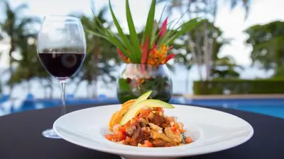a plate of food and a glass of wine on a table at Stunning Ocean View Villa in Playa Coco and Ocotal in Ocotal