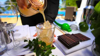 a person pouring a drink into a glass on a table at Stunning Ocean View Villa in Playa Coco and Ocotal in Ocotal