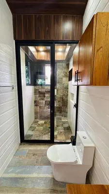 a bathroom with a toilet and a glass door at Paraiso Terrenal Chalet in San Isidro