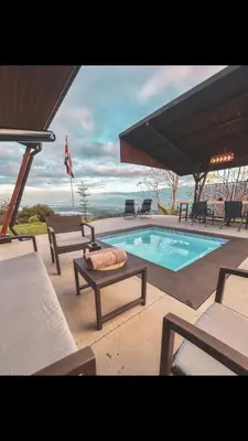 a swimming pool with chairs and a table next to it at Paraiso Terrenal Chalet in San Isidro