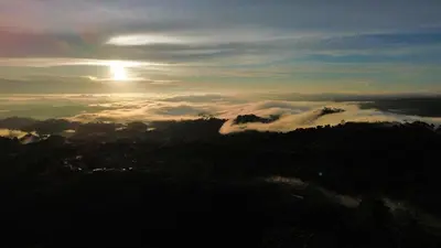 a view of the sun rising over a mountain with clouds at Paraiso Terrenal Chalet in San Isidro