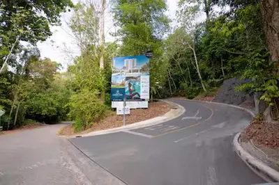 a winding road with a sign on the side of it at Playa Mantas - 7th Floor - Sea View - Beach Club Access - Balcony - Beach in Punta Leona