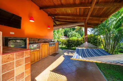 a hammock in a kitchen with an orange wall at BBQ, Pool, Garden, Smart TV, Parking, AC, King Bed, Laundry facilities - Villaggio 376 in Potrero