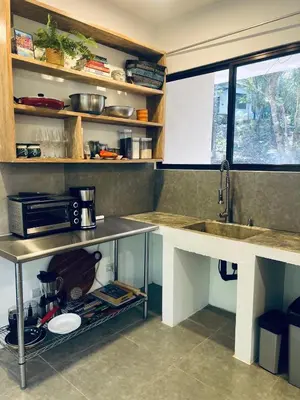 a kitchen with a sink and a counter with a microwave at Peaceful house in nature 5 min drive from beach in San Juanillo