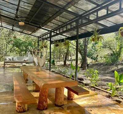 a wooden table sitting under a pavilion in a garden at Peaceful house in nature 5 min drive from beach in San Juanillo