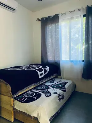 a bedroom with two beds and a window at Peaceful house in nature 5 min drive from beach in San Juanillo