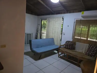 a living room with a blue couch and a chair at Casa Tica in Playa Flamingo