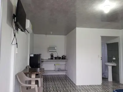 a small kitchen with a table and a television in a room at La Loma Lodge in Aguas Zarcas