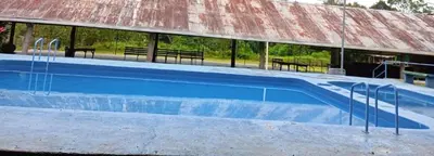 a large swimming pool with a red roof at La Loma Lodge in Aguas Zarcas
