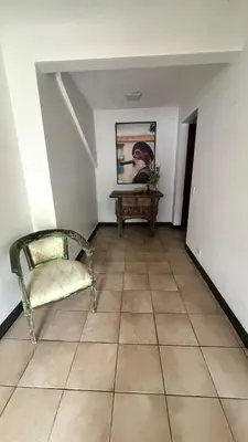 a room with a chair and a painting on the wall at Bonsai House in Brasil