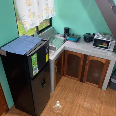 a small kitchen with a sink and a stove at Cinnamon Lodge in Upala