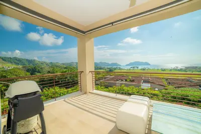 a room with a balcony with a pool and a chair at Miramar 5D -3 bedr 3 bath Ocean View in Herradura