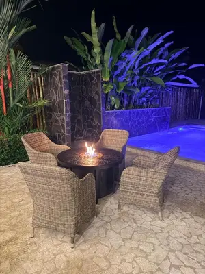 a fire pit with chairs and a table with a candle at Casa Adam in Pochote