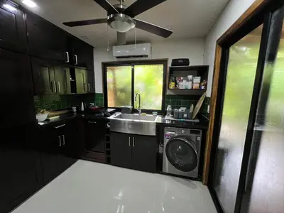 a kitchen with a sink and a washing machine at Casa Adam in Pochote