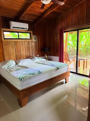 a bedroom with a large bed with a ceiling fan at Casa Adam in Pochote