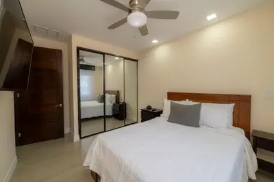 a bedroom with a white bed with a ceiling fan at Miramar 3B - 3 bedr 3 bath Ocean View in Herradura