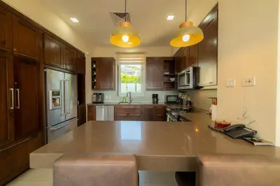 a kitchen with wooden cabinets and a large kitchen island at Miramar 3B - 3 bedr 3 bath Ocean View in Herradura