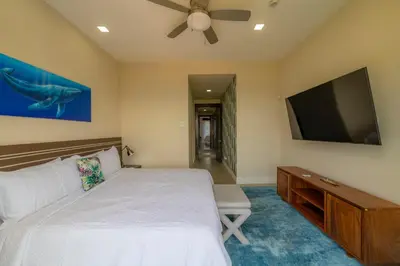 a bedroom with a bed and a flat screen tv at Miramar 3B - 3 bedr 3 bath Ocean View in Herradura