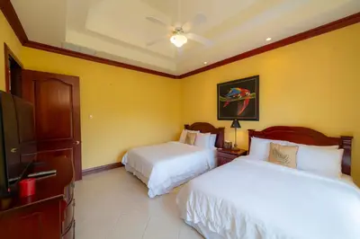 a hotel room with two beds and a tv at Bella Vista 8B 3 bedr 3 1 and half bath in Jacó