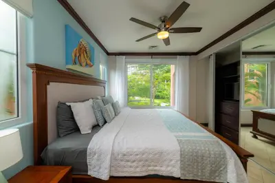 a bedroom with a bed with a ceiling fan and a window at Altavista 4C 3 bdr 3 bath Ocean View in La Mona