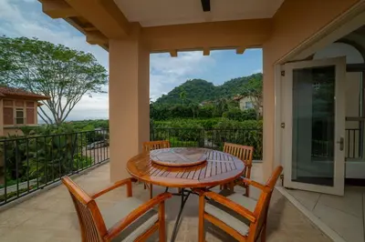 a table and chairs on a balcony with a view of the ocean at Bella Vista 1C - 3 bdr - 3 1 and half bath in La Mona