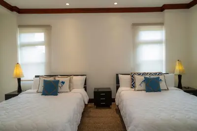 two beds in a room with two windows at Bella Vista 1C - 3 bdr - 3 1 and half bath in La Mona