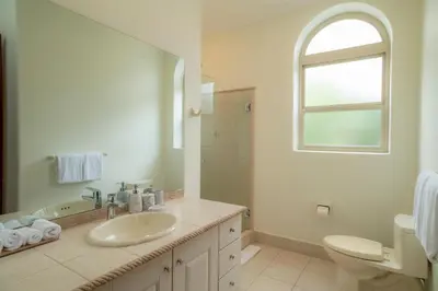 a bathroom with a sink and a toilet and a window at Bella Vista 1C - 3 bdr - 3 1 and half bath in La Mona