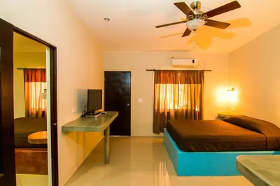 a bedroom with a bed and a ceiling fan at Playa Negra Surf Lodge in Playa Negra