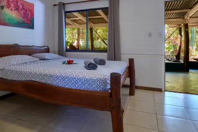 a bedroom with a bed with towels and flowers on it at Playa Negra Surf Lodge in Playa Negra