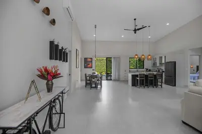 a living room and kitchen with a couch and a table at Brand New Villa! - Just 10 Mins Walk To The Beach in Uvita