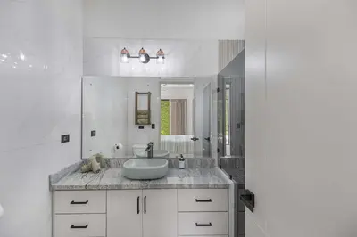 a white bathroom with a sink and a mirror at Brand New Villa! - Just 10 Mins Walk To The Beach in Uvita