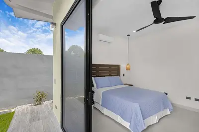 a bedroom with a bed and a sliding glass door at Brand New Villa! - Just 10 Mins Walk To The Beach in Uvita