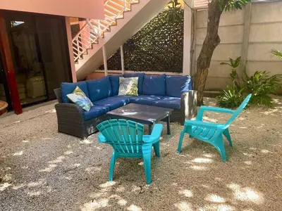 a blue couch and two chairs and a table at El Papagayo Verde 5 min walk to the beach and downtown in Coco